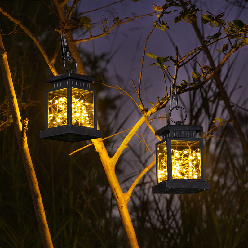 Solar lantern hanging from tree backyard ambient lighting